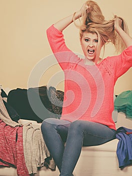 Woman does not know what to wear sitting on couch