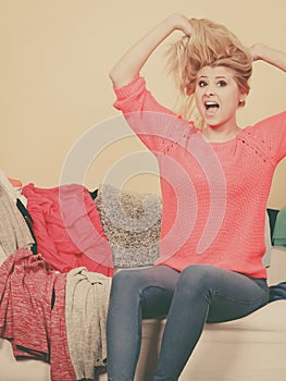 Woman does not know what to wear sitting on couch