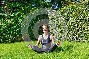 Woman does yoga sitting on the grass