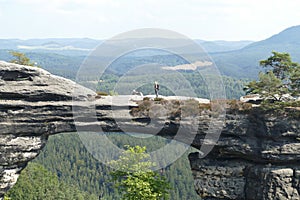 Woman with a dog on the rocks.