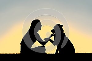 Woman and Dog Shaking Hands Sunset Silhouette photo