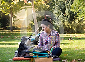 Woman and dog sitting on grass in backyard