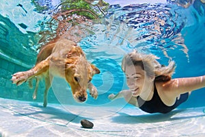 Woman with dog swimming underwater