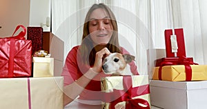 Woman with dog video call with camera among christmas gifts