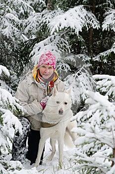 Woman with a dog on walk in a winter wood