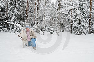 Woman with a dog on walk in a winter wood