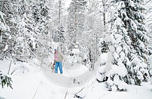 Woman with a dog on walk in a winter wood