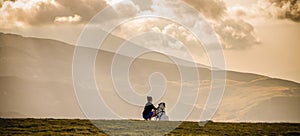 woman and dog watching amazing panorama of heavenly lights at sunset in high mountains