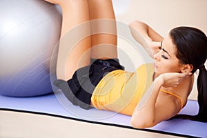 Woman doing abdominal muscles with a fitness ball