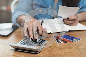 Woman doing accounting home finance expenses and calculate credit card monthly debt to bills payment