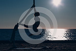 Woman doing air yoga on the beach.