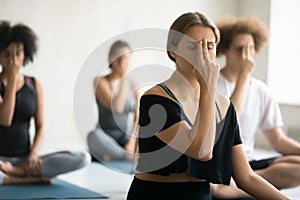 Woman doing Alternate Nostril Breathing exercise close up, practicing yoga