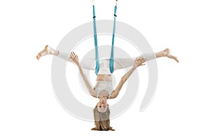 Woman doing antigravity yoga with yoga hammock isolated on white background. Girl hangs upside down