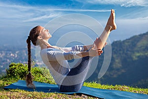 Woman doing Ashtanga Vinyasa Yoga asana Navasana - boat pose