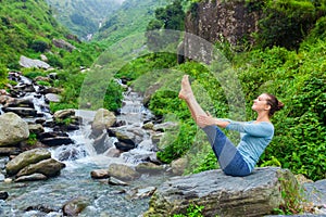 Woman doing Ashtanga Vinyasa Yoga asana Navasana outdoors