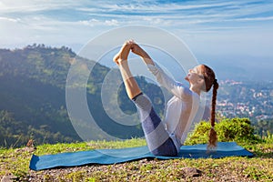 Woman doing Ashtanga Vinyasa Yoga asana outdoors photo