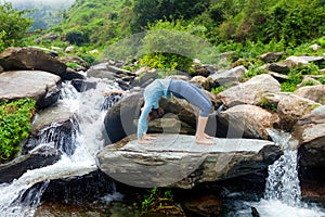 Woman doing Ashtanga Vinyasa Yoga asana Urdhva Dhanurasana - up