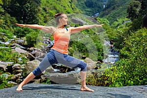 Woman doing Ashtanga Vinyasa Yoga Virabhadrasana 2 Warrior pose photo