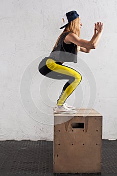 Woman doing box jumps in the gym