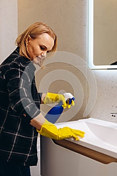 Woman doing chores in bathroom, cleaning of water tap