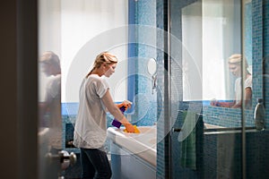 Woman doing chores and cleaning bathroom at home