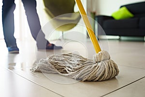 Woman Doing Chores Cleaning Floor At Home Focus on Mop photo