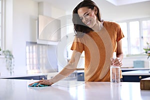 Woman Doing Chores In Kitchen At Home Cleaning And Disinfecting Surface With Spray