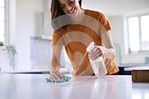 Woman Doing Chores In Kitchen At Home Cleaning And Disinfecting Surface With Spray