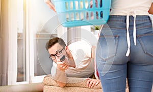 Woman doing chores while man watching tv