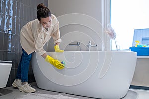 A woman doing cleaning at home and disinfecting the bathroom