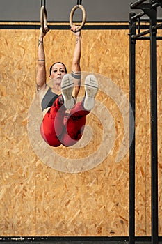 Woman doing core exercises using olympic ring in a gym