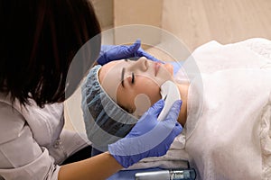 Woman doing cosmetic procedures in spa clinic.