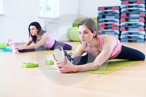 Woman doing cross split exercise working out her hip abductor muscles and ligaments. Fit female athlete stretching