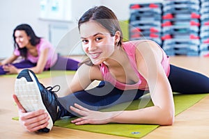 Woman doing cross split exercise working out her hip abductor muscles and ligaments. Fit female athlete stretching