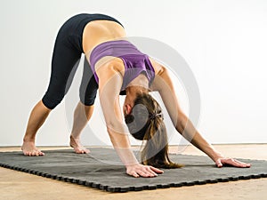 Woman doing downward dog yoga position photo