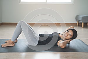 Woman doing exercise abs lying on the mat at home