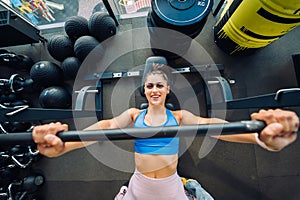 Woman doing exercises with barbell on a bench press training