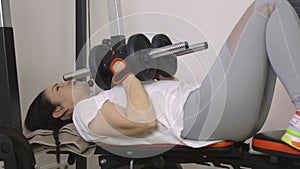 Woman doing exercises with dumbbells on bench at home