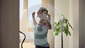Woman doing exercises with an elastic band in the living room at home. Healthy life concept