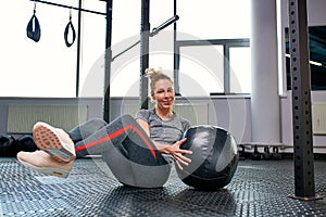 Woman doing exercises with fitball in fitness gym class. Engaging core abdominal muscles. Image concept of healthy photo