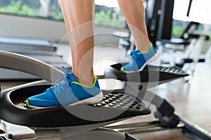 Woman doing exercises in the gym on elliptical cross trainer