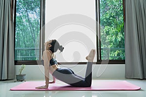 Woman Doing Exercises at home,people and healthy lifestyle concept -female wearing sportswear practicing yoga doing stretching on