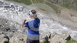 A woman is doing exercises in the mountains, she is engaged in meditation and yoga. Healthy lifestyle.