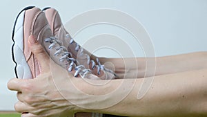 Woman doing exercises - stretching, touching her toes. Feet close up