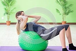 The woman doing exercises with swiss ball