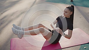 a woman is doing exercises on a yoga mat in a park