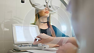 Woman doing eye test with optometrist in medical center