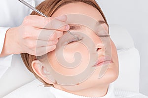 Woman doing eyelashes lamination, staining, curling, laminating and extension for lashes