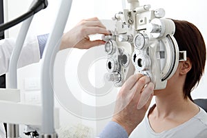 Woman doing eyesight measurement with optical phoropter