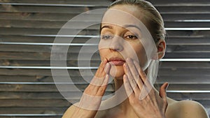 Woman doing face fitness, aging chang in the muscles of the face